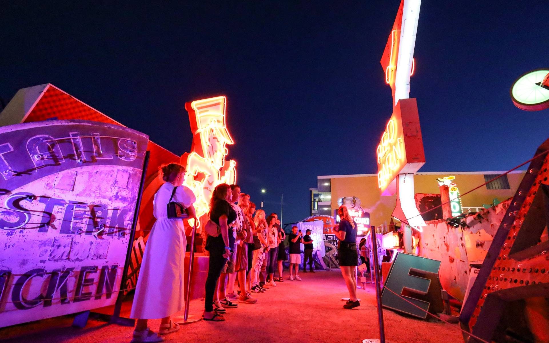 A group of visitors taking a tour at The Neon Museum's Neon Boneyard