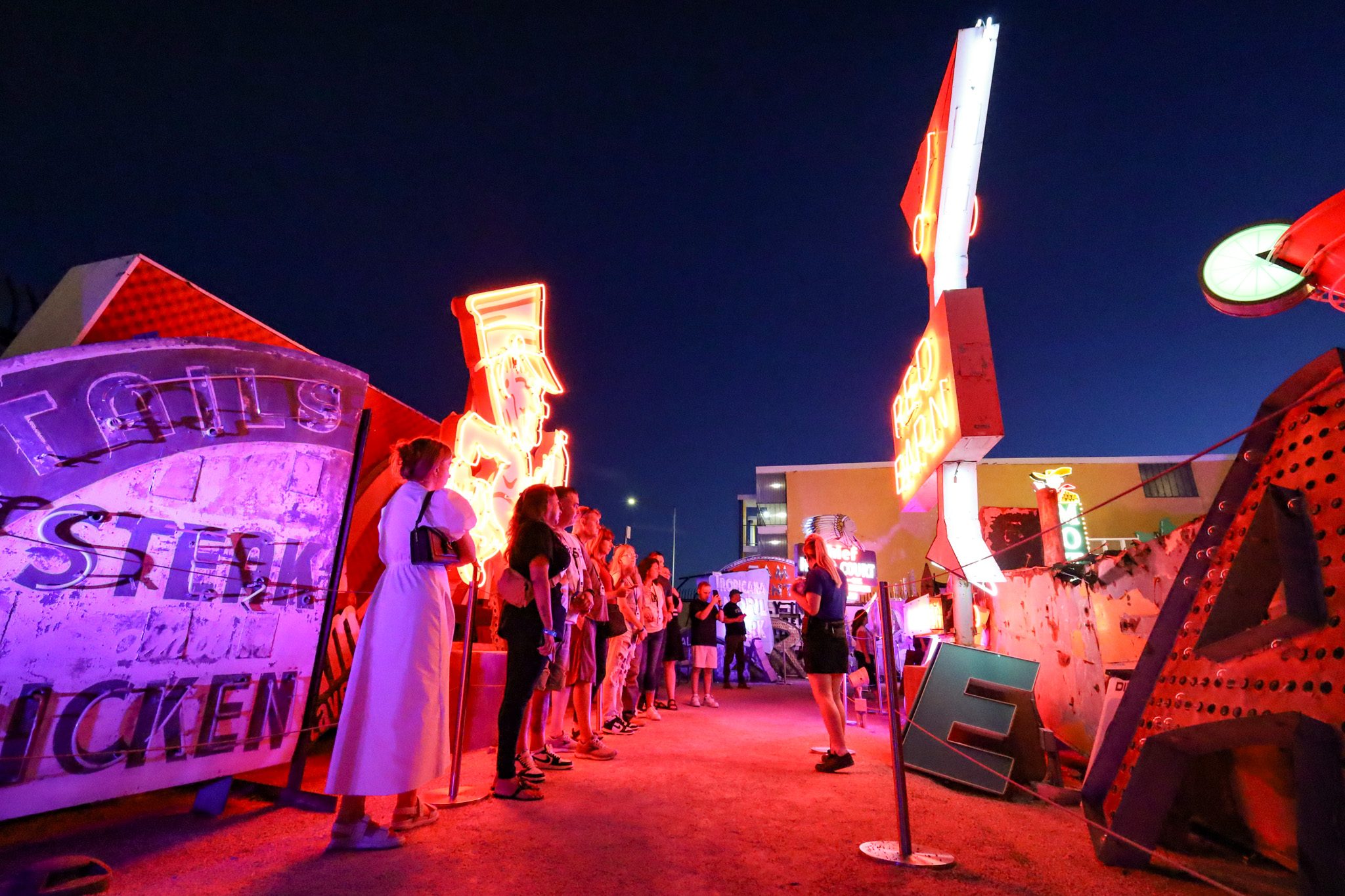 A group of visitors taking a tour at The Neon Museum's Neon Boneyard