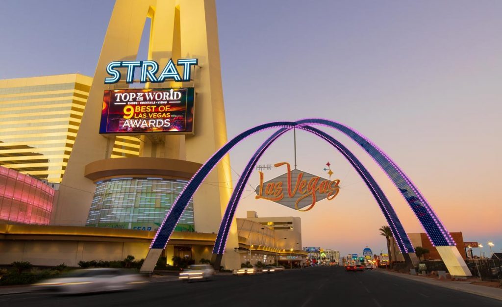 An image of the 80-foot-tall illuminated blue arches, called the Gateway Arches, spanning Las Vegas Boulevard south of the Strat Hotel