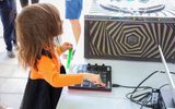 A child playing with a sound system in the Neon Boneyard.