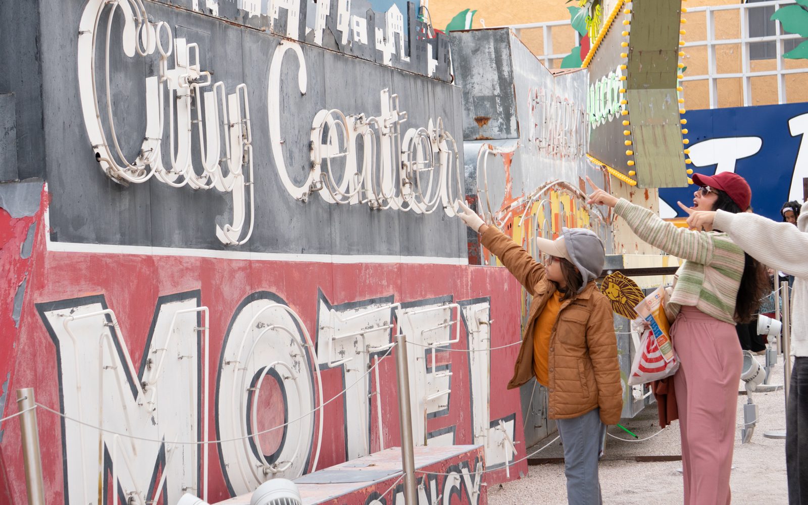A mom and their children excited to see the City Center Motel sign.