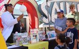 Children and family members around a booth in the Neon Boneyard.