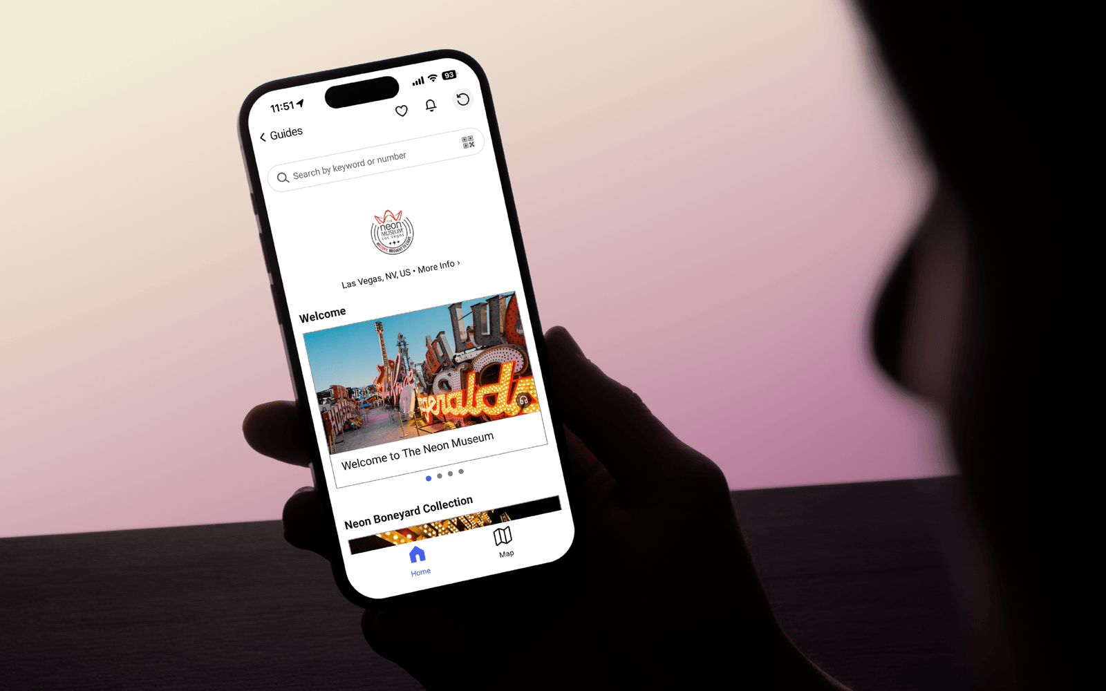 Guest looking at cell phone with The Neon Museum digital guide preview.