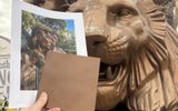 Museum employee comparing the Siegfried & Roy sculpture against a paint sample and a historic image to ensure accuracy in the color matching process