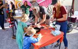 Children in costumes doing activities during STEAM Family Fest.