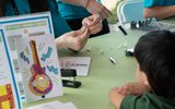 The Neon Museum's Learning Team adding a LED light to a child's sign coloring page.