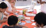 Children writing a postcard during STEAM Family Fest.