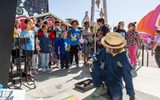 Children watch the chalk artist paint.